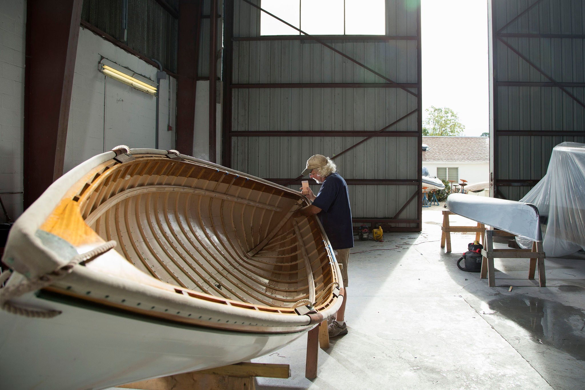 Craftsperson working indoors at boatyard to maintain boats
